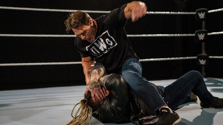 John Cena, wearing an nWo shirt, gets ready to strike a fallen Bray Wyatt on the ring canvas during the Firefly Funhouse match.