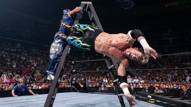 Eddie Guerrero falls to the mat as Rey Mysterio climbs the ladder during the 2005 Custody of Dominik Mysterio ladder match.