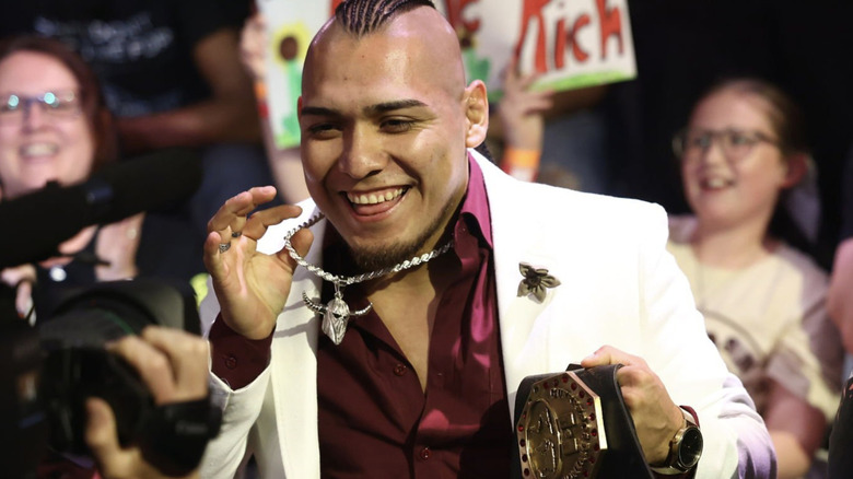 El Hijo del Vikingo shows off a silver bull necklace and an AAA championship as he makes his way through an NXT crowd.