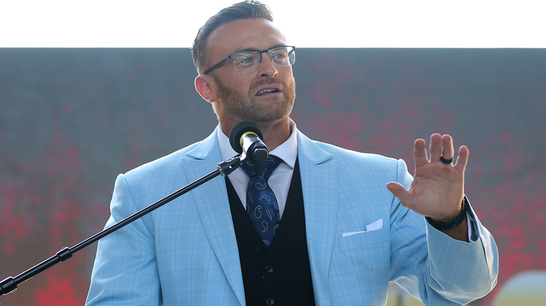 Nick Aldis wearing a blue suit