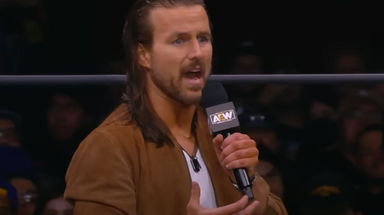 Adam Cole speaking on a microphone