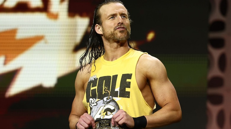 Adam Cole wearing a yellow tank top