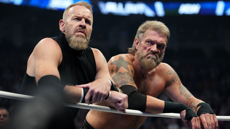 Christian Cage and Adam Copeland lean over the ropes, scowling, before a match at AEW All Out 2025.