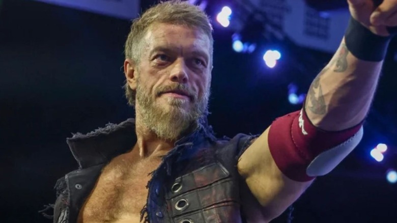 Adam Copeland stands on the stage and points to the audience before a match on AEW TV.