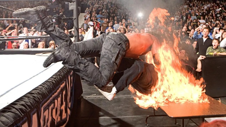 Edge and Mick Foley through a flaming table