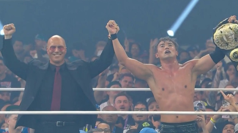 Kazuchika Okada celebrates with the AEW Unified Championship