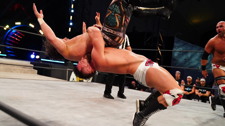 Cash Wheeler suplexes Kenny Omega as Dax Harwood looks on at AEW All Out 2020