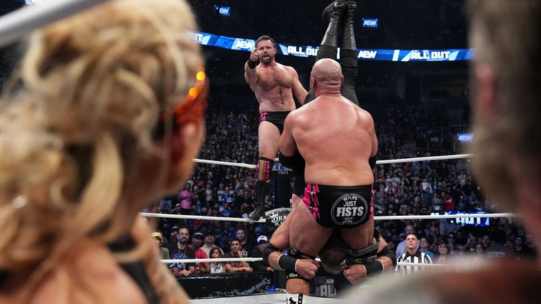 Adam Copeland and Beth Phoenix frame a pointing Cash Wheeler and a piledriving Dax Harwood at AEW All Out 2025