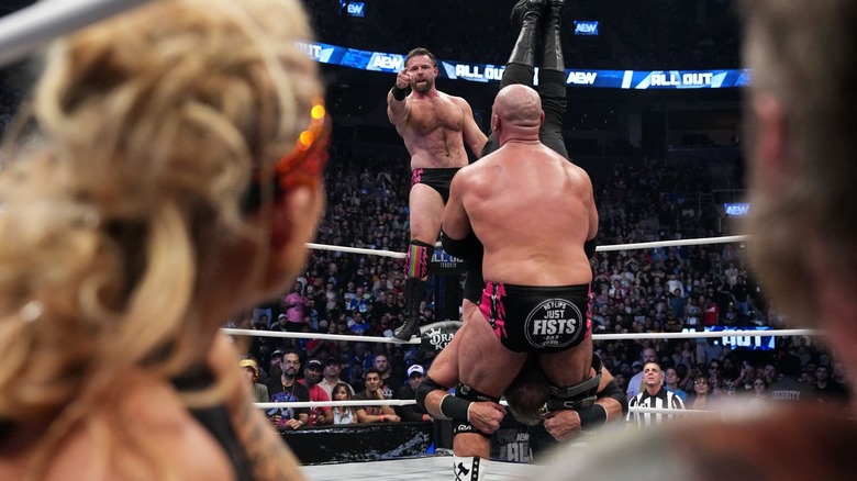 Beth Copeland and Cope watch as FTR prepare Christian Cage for a Spiked Piledriver.
