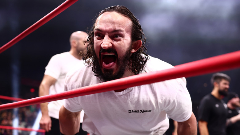 Pac yells at an opponent through the ropes, while the other Death Riders stand in the ring, during an episode of "AEW Dynamite."