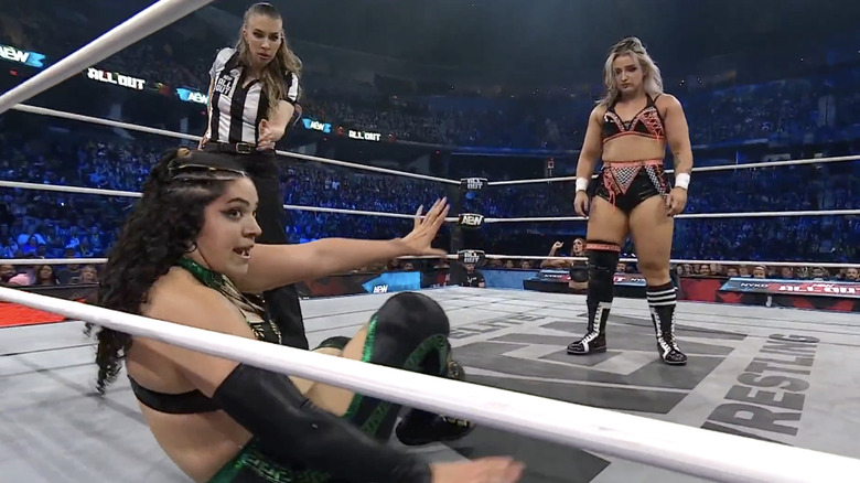 Luna standing over Persephone inside the ring