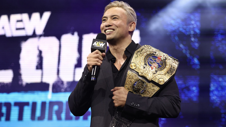 Okada smiling with his International Championship on his shoulder