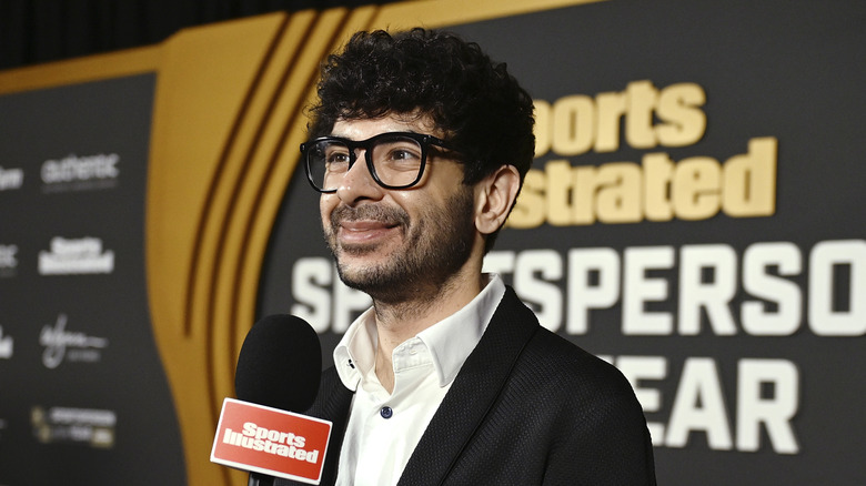 Tony Khan with a Sports Illustrated microphone