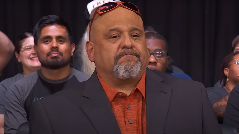 Taz wearing a grey suit jacket and orange shirt