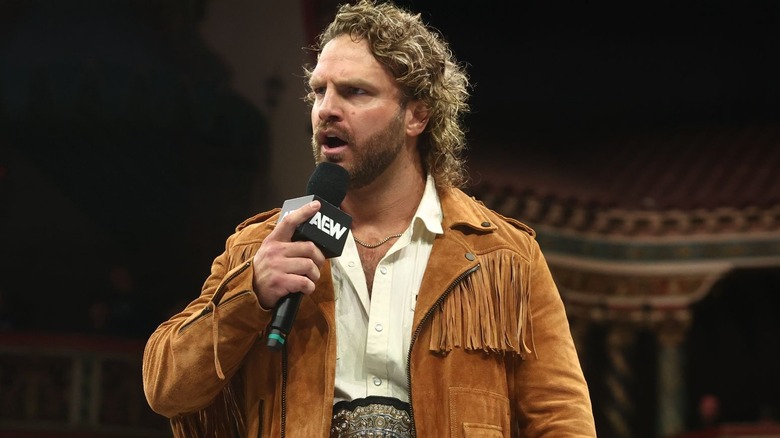 Adam Page is holding a microphone