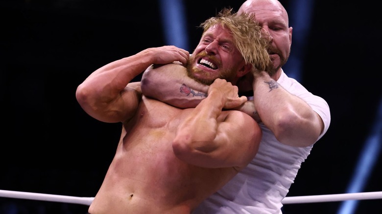 Jon Moxley putting Orange Cassidy in a chokehold