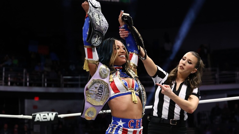 Mercedes Moné in the ring with her belts