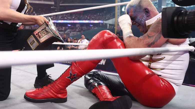 Dustin Rhodes is handed the AEW TNT title in the corner at All In