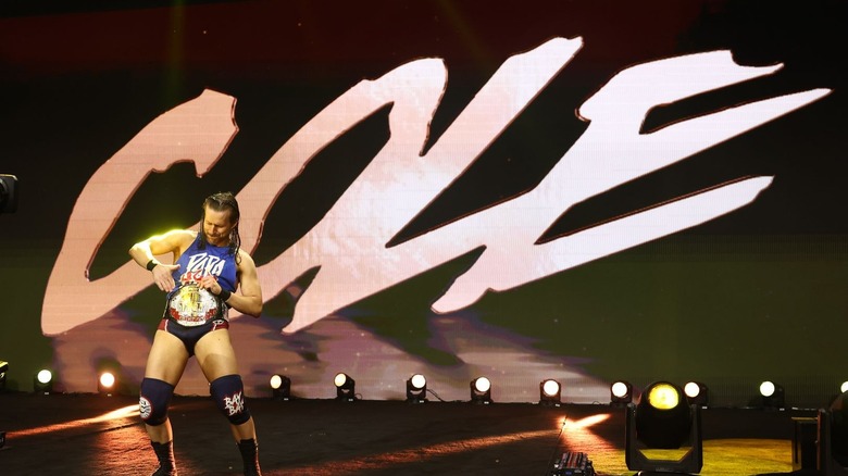 Adam Cole patting his title