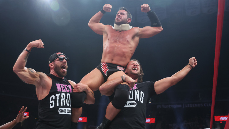 Mike Bennett and Matt Taven hold Roderick Strong on their shoulders