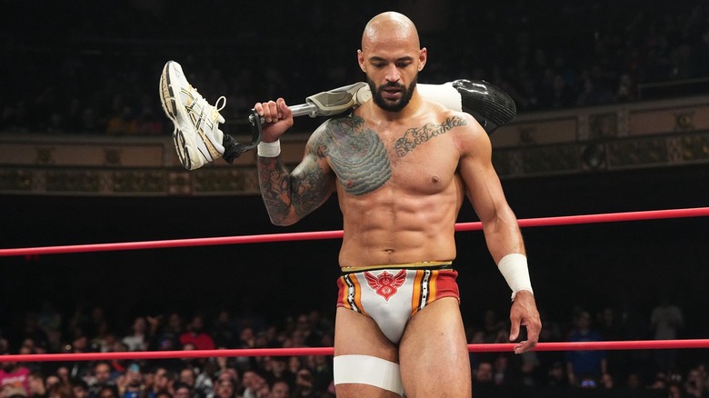 AEW's Ricochet holding a prosthetic leg