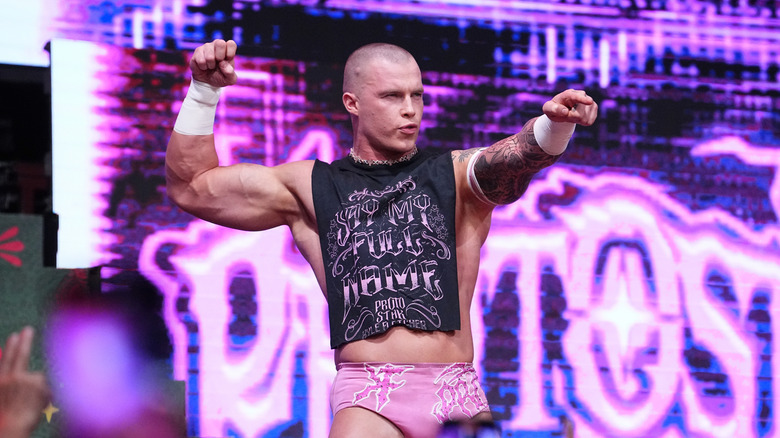 Kyle Fletcher poses and flexes on the stage before a match on an episode of 