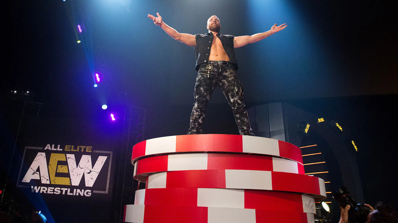 John Moxley poses atop a stack of giant poker chips at AEW Double or Nothing 2019
