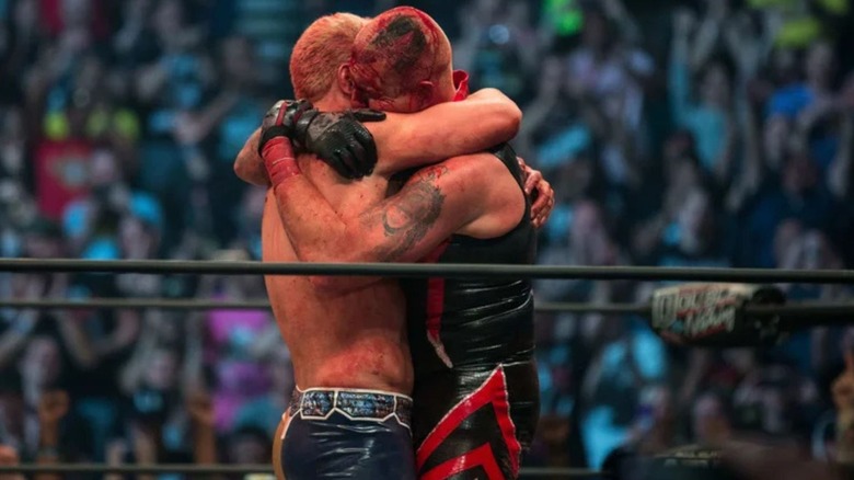 A bloodied Dustin Rhodes hugs Cody Rhodes in the middle of the ring following their match at AEW Double or Nothing in 2019.