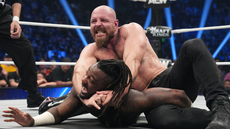 AEW World Champion Jon Moxley puts Swerve Strickland in a submission hold in the middle of the ring during an episode of 