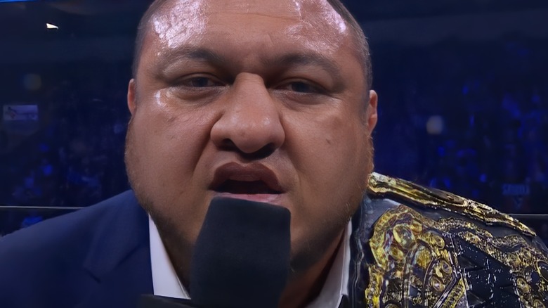 Samoa Joe with title on his shoulder and microphone