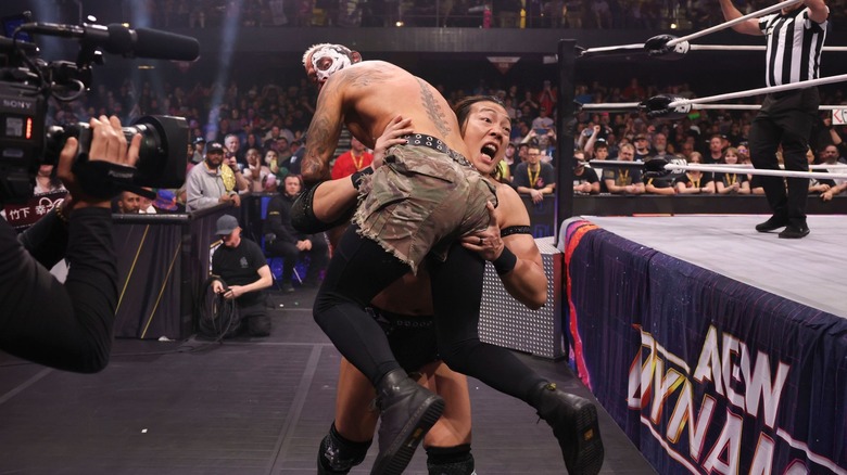 Konosuke Takeshita charges with Darby Allin on his shoulder