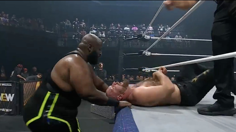 Taylor with Moxley laying on the ring apron