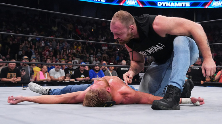 Jon Moxley kneels over Orange Cassidy