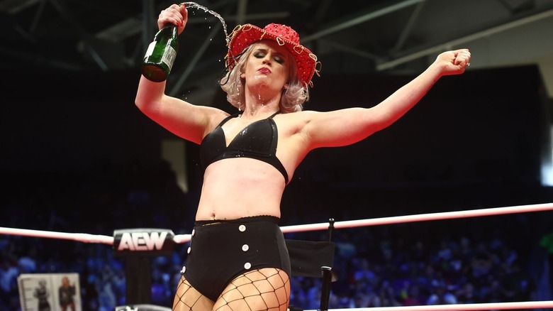 Toni Storm spills champagne while drinking it and wearing a red hat on "AEW Dynamite"