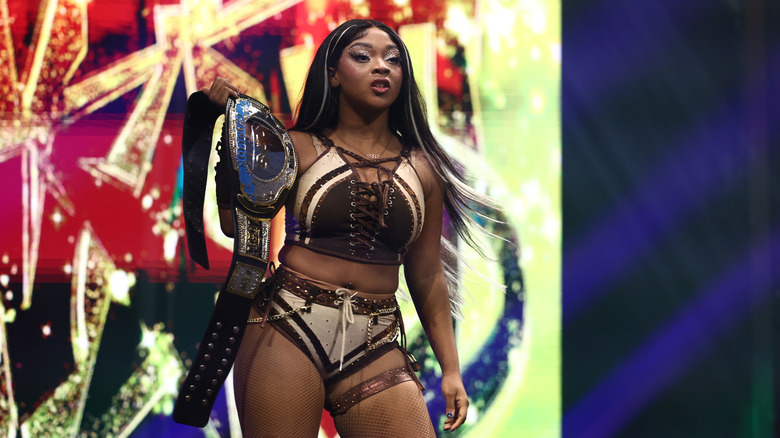 Maya World poses with the TBS Championship as she looks to the ring following a match on AEW programming.