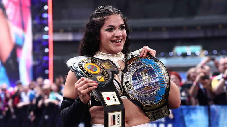 CMLL World Women's Champion, and new AEW TBS Champion, Persephone, poses with both titles at ringside after her win at AEW All In London 2026.