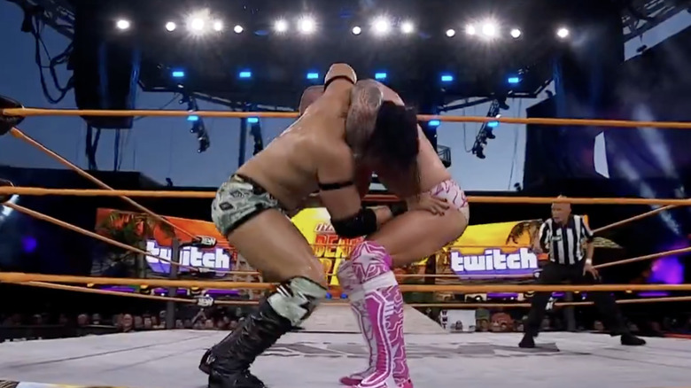 Takeshita and Fletcher teetering on the ring apron