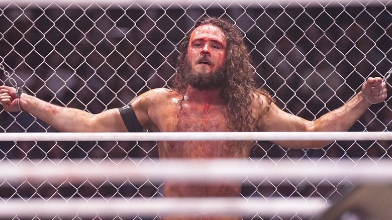 Jack Perry, handcuffed to a steel cage.