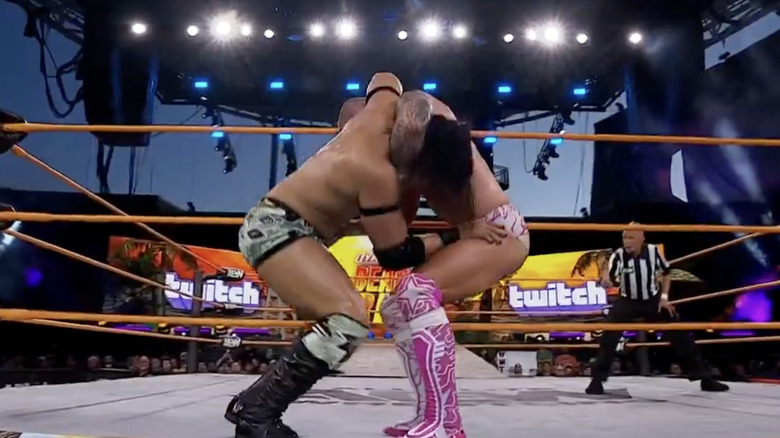 Takeshita and Fletcher teetering on the ring apron
