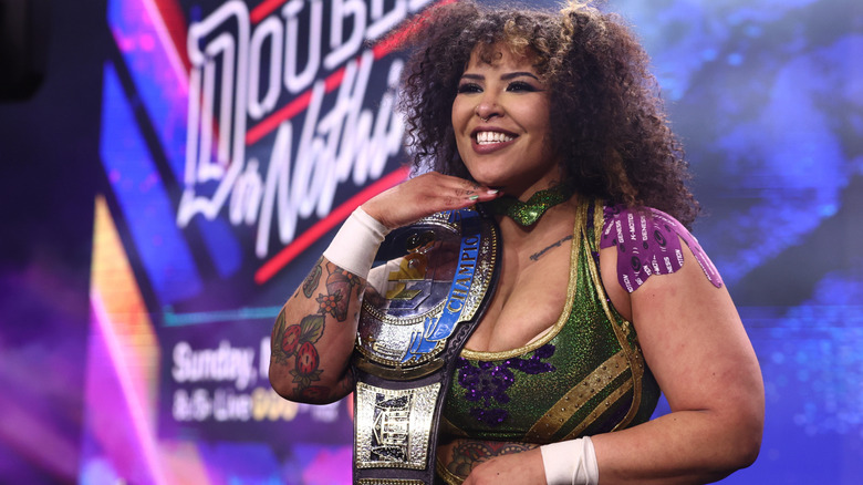 Willow Nightingale poses on the stage, TBS Championship on her shoulder, after a match on an episode of "AEW Dynamite."