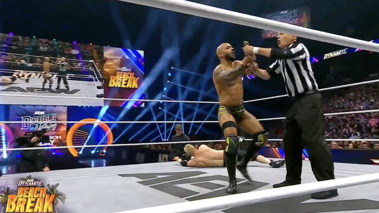 The referee taking the scissors from Ricochet
