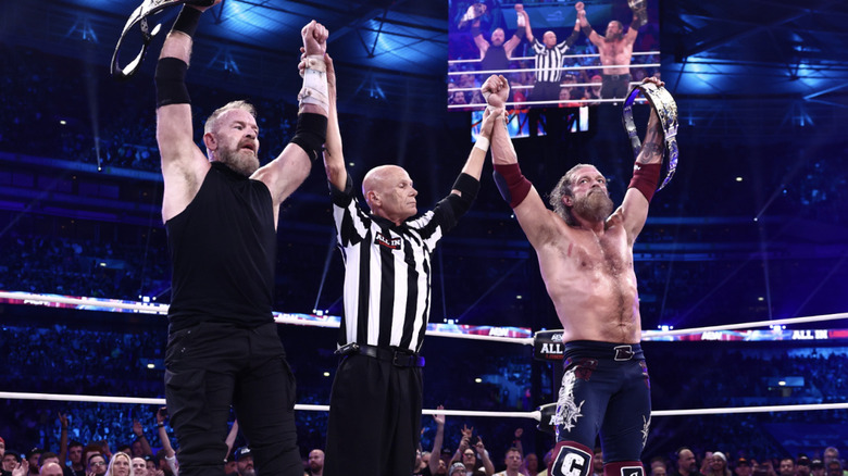 The referee raising Cage and Copeland's arms