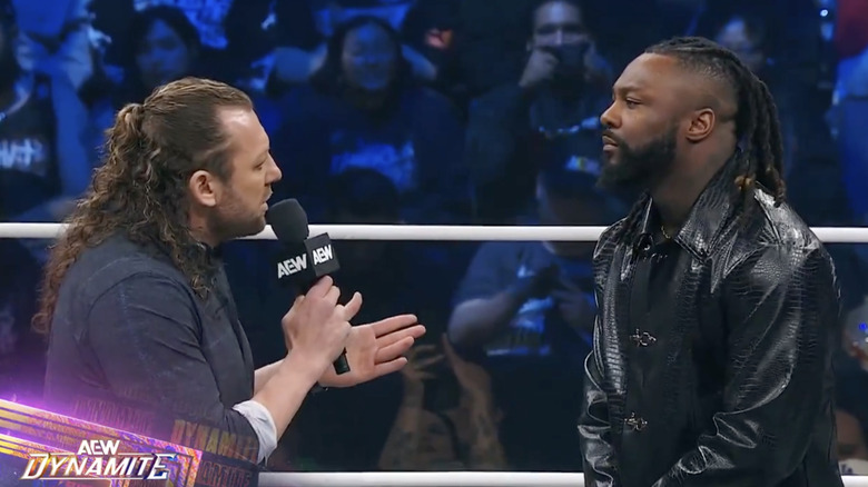 Omega and Strickland speaking with one another in the ring