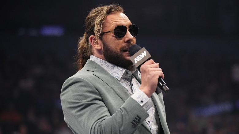 Kenny Omega speaking in sunglasses.