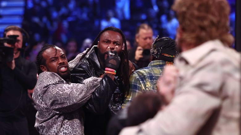 Austin Creed holds back Swerve Strickland, as Swerve threatens Hangman Page