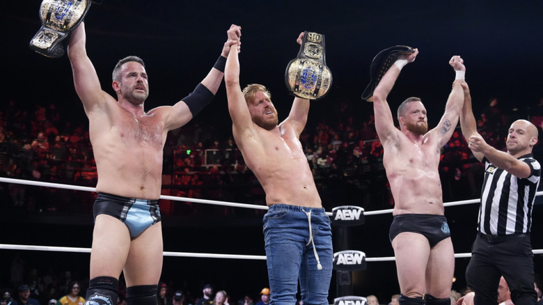 The Conglomeration holding up their AEW World Trios Championship belts