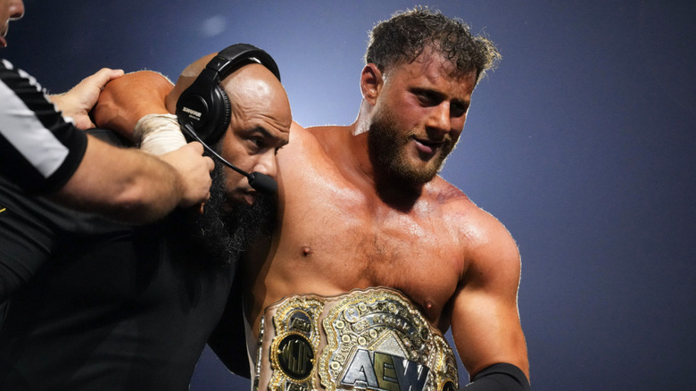 MJF being helped as he holds the AEW World Championship