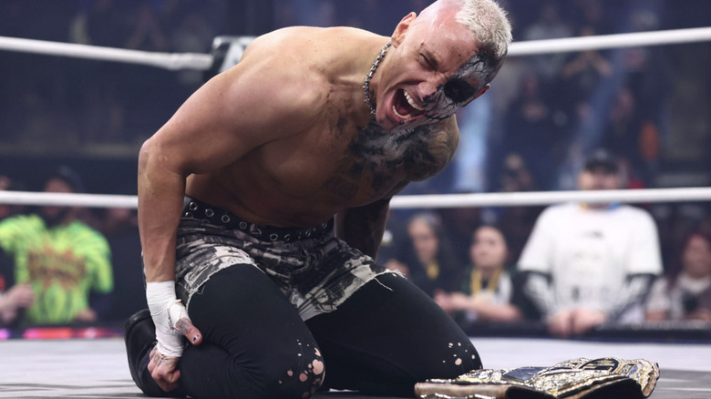 Allin kneeling in the ring with his AEW World Championship belt