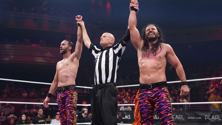 Young Bucks with their hands raised