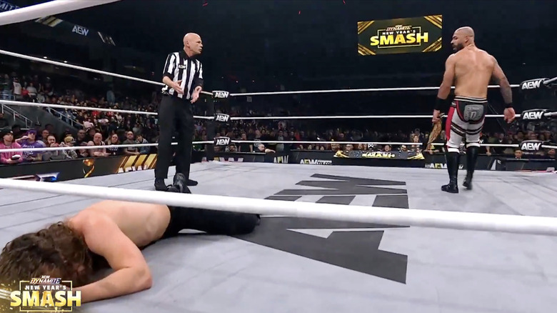 Ricochet standing over Perry in the ring